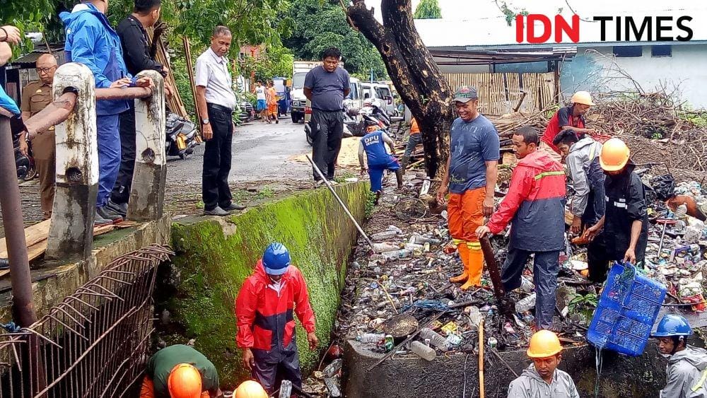 Sejumlah petugas membersihkan pintu air Tamalabba di Kecamatan Ujung Tanah, Senin (6/1). IDN Times/Asrhawi Muin