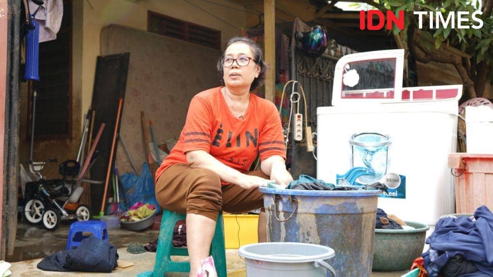 Korban banjir di Perumahan Ciledug Indah, Tangerang, Banten, mencuci pakaiannya di halaman rumahnya. (IDN Times/Fiqih Damarjati)