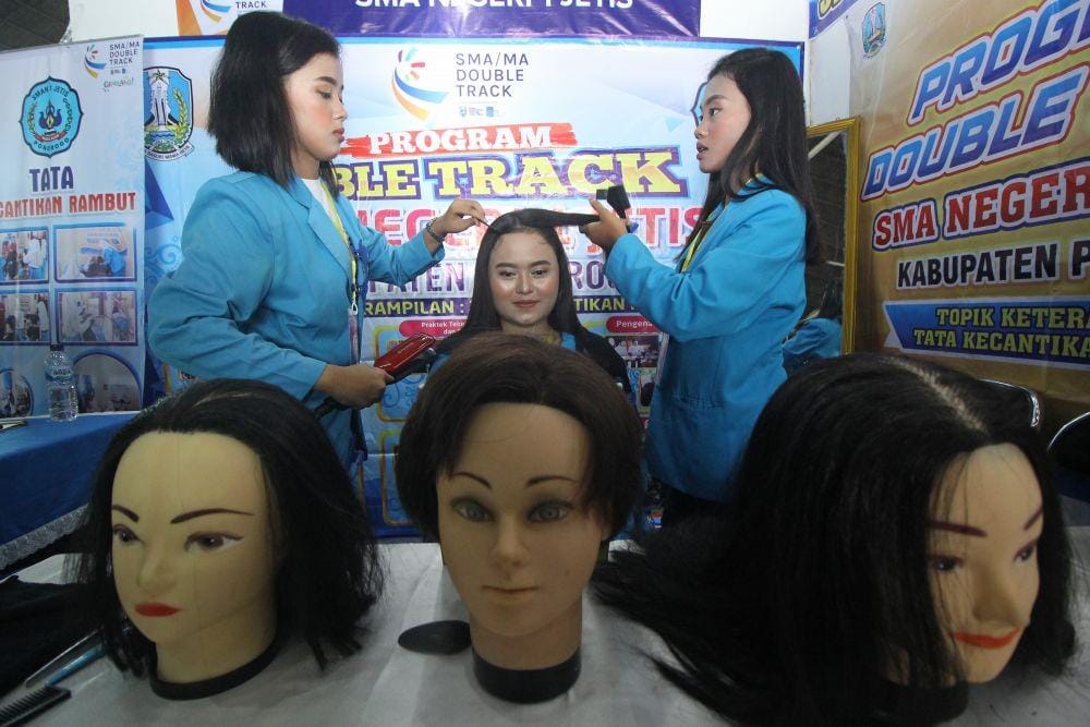 Pelajar SMA Negeri 1 Jetis, Ponorogo menunjukkan tata cara merawat rambut saat "Festival SMA/MA Double Track" di JX International Expo, Surabaya, Jawa Timur. ANTARA FOTO/Moch Asim