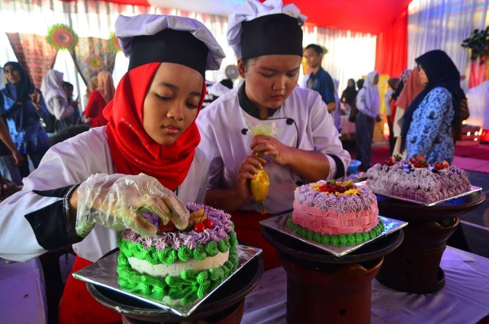 Siswa memperagakan menghias kue pada acara Gelar Karya Siswa SMK di SMK Negeri 1 Kudus, Jawa Tengah. ANTARA FOTO/Yusuf Nugroho