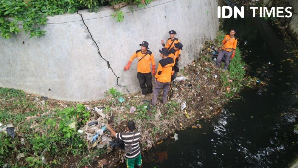 Petugas kebersihan tengah membersihkan sampah di Sungai Pengempaan Kota Cirebon (IDN Times/Wildan Ibnu)