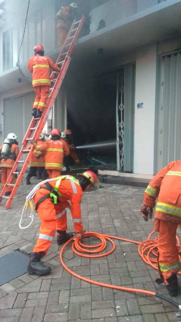Petugas PMK Kota Surabaya memadamkan kebakaran yang melahap dealer motor di Pucang Anom, Rabu pagi (8/1). Dok. Dinas PMK Kota Surabaya