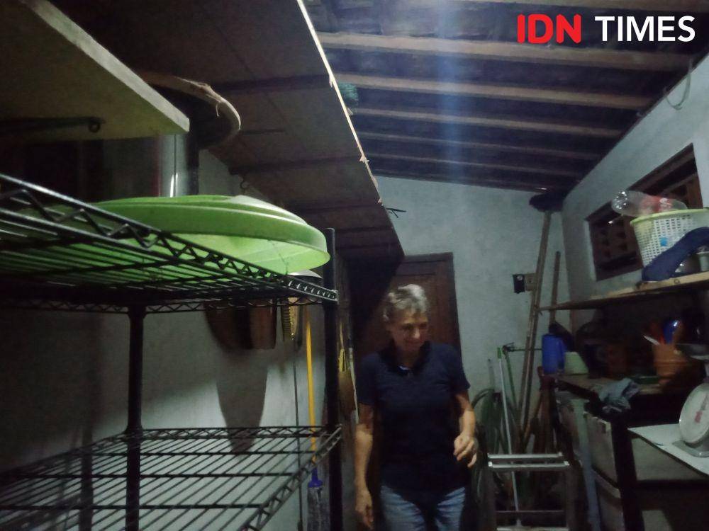 Elisabeth saat menunjukan tempat di mana ia menemukan ular dalam gudang rumahnya, Rabu (8/1). (IDN Times/Tunggul Damarjati)