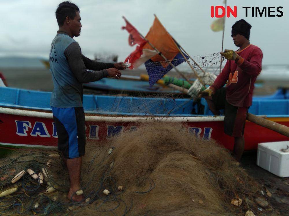 Nelayan di Pantai Samas sedang membersihkan jaring dari sampah dan ikan. IDN Times/Daruwaskita