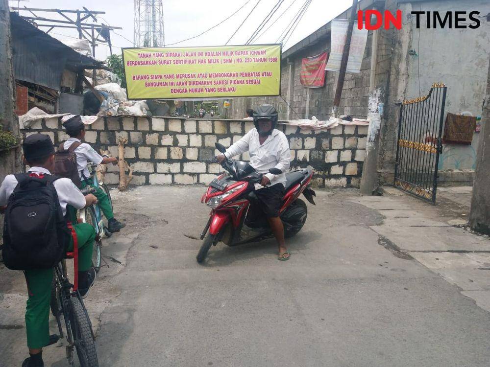 Pengendara motor terpaksa putar balik saat mengetahui ada tembok yang berdiri di tengah Jalan Tambak Wedi Surabaya, Rabu (8/1). IDN Times/Dida Tenola