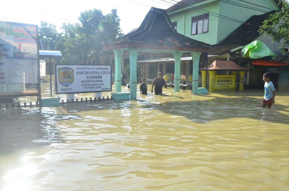 Warga berjalan menembus banjir di Desa Gubug, Gubug, Grobogan, Jawa Tengah, Kamis (9/1). ANTARA FOTO/Yusuf Nugroho