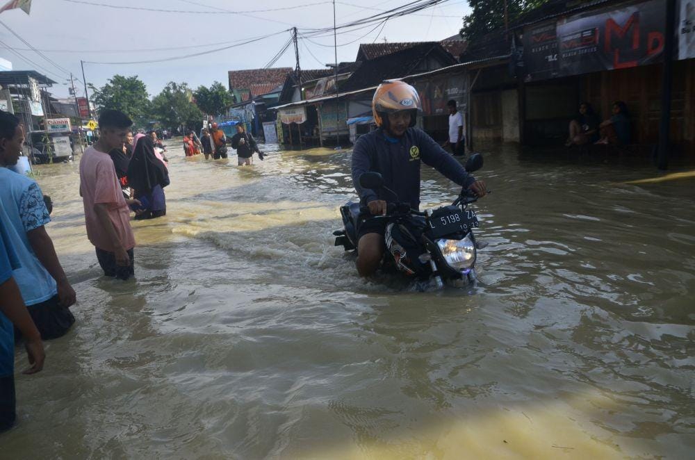 Pengendara sepeda motor melintasi banjir di Desa Gubug, Gubug, Grobogan, Jawa Tengah, Kamis (9/1). ANTARA FOTO/Yusuf Nugroho