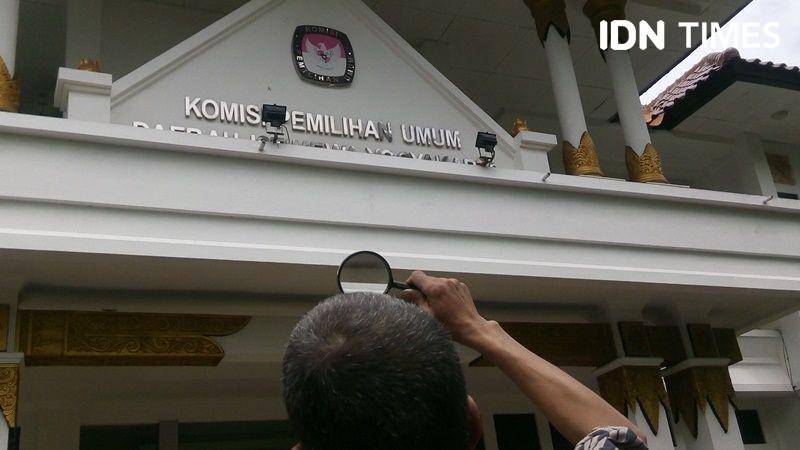 Aktivis JPW melihat tulisan KPU DIY dengan kaca pembesar, 10 Januari 2020. IDN Times/Pito Agustin Rudiana