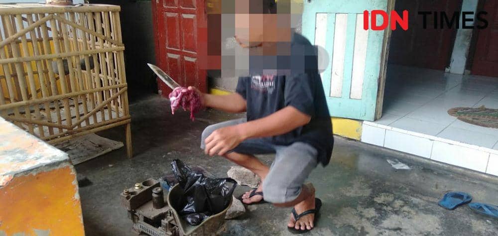 Salah seorang penyembelih anjing di Bantul menimbang daging anjing pesanan konsumen. IDN Times/Daruwaskita