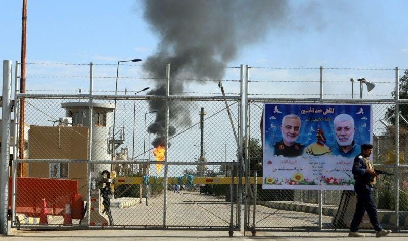 Poster komandan milisi Irak Abu Mahdi al-Muhandis dan komandan militer Iran Qassem Soleimani tergantung di pintu ladang minyak West Qurna-1, yang dioperasikan oleh ExxonMobil, di Basra, Irak, pada 9 Januari 2020. (ANTARA FOTO/REUTERS/Essam al-Sudani)