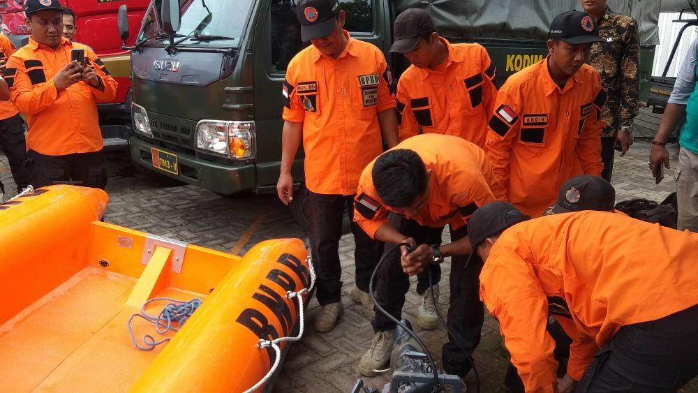 Petugas BPBD Kabupaten Lamongan tengah menyalakan mesin perahu karet. IDN Times/Imron