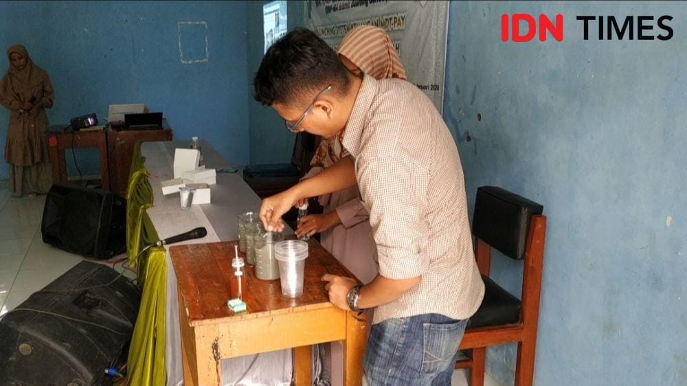 Demonstrasi cara penjernihan air tercemar limbah batu alam. (IDN Times/Wildan Ibnu)