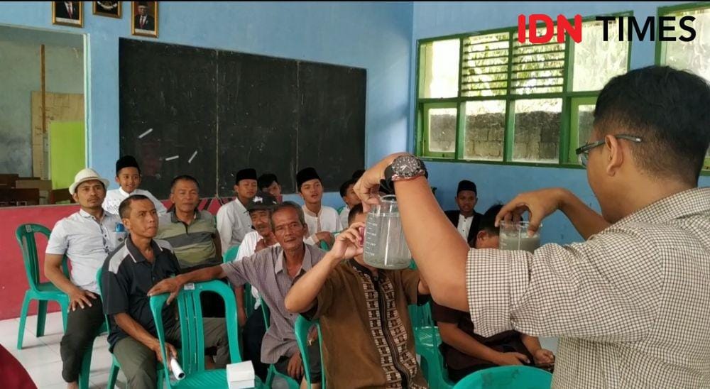 Demonstrasi cara penjernihan air tercemar limbah batu alam. (IDN Times/Wildan Ibnu)
