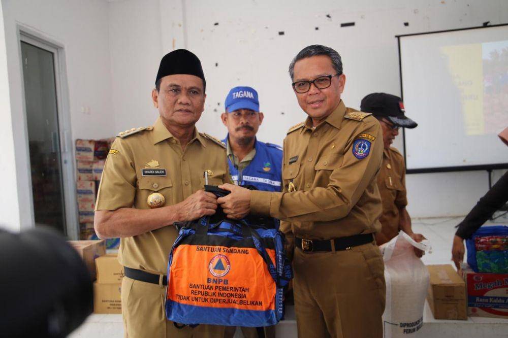 Gubernur Sulsel Nurdin Abdullah dan Bupati Barru Suardi Saleh menyerahkan bantuan kepada korban terdampak banjir di Kabupaten Barru, Senin (13/1). IDN Times/Istimewa