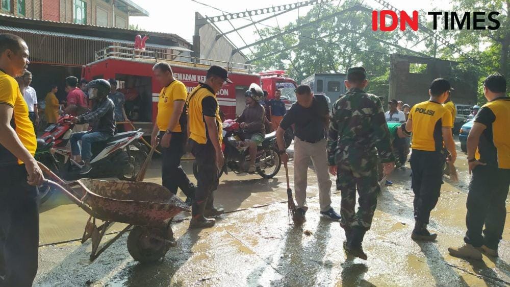 Petugas gabungan penanggulangan bencana banjir Kalijaga Kota Cirebon membersihkan lumpur sisa banjir. (IDN Times/Wildan Ibnu)