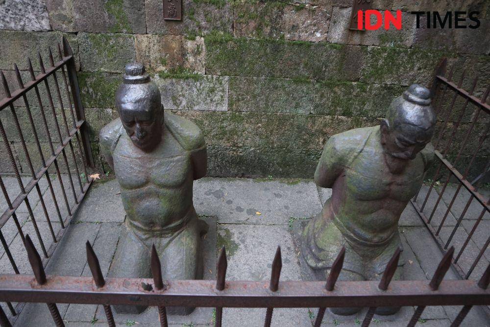 Patung 2 orang anak buah perdana menteri yang berlutut di depan makam Jenderal Yue Fei (IDN Times/Mela Hapsari)