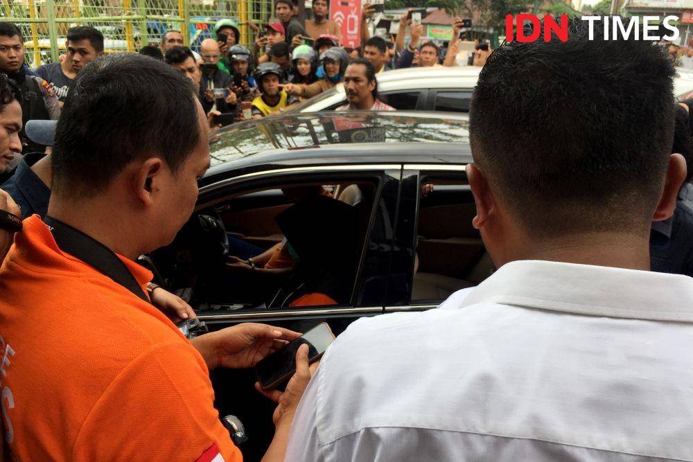 JP dan ZH berada dalam satu mobil saat reka adegan kasus pembunuhan Hakim Jamaluddin  berada di pelataran Coffee Town, Jalan Ringroad, Medan (IDN Times/Prayugo Utomo)