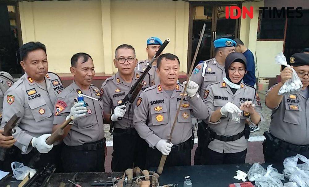 Kasat Sabhara Polrestabes Medan AKBP Sonny Siregar (pegang samurai) didampingi pejabat lainnya menunjukkan barang bukti yang diamankan dari Desa Mencirim (IDN Times/Fadli Syahputra)