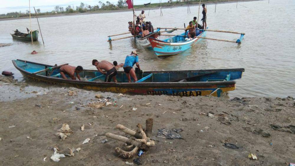Warga Kebumen setelah mengevakuasi perahu penambang pasir yang terbalik di Sungai Lukulo, Dukuh Sidomulyo, Desa Tanggulangin, Kecamatan Klirong, Kebumen, Senin (13/1). Humas Polres Kebumen