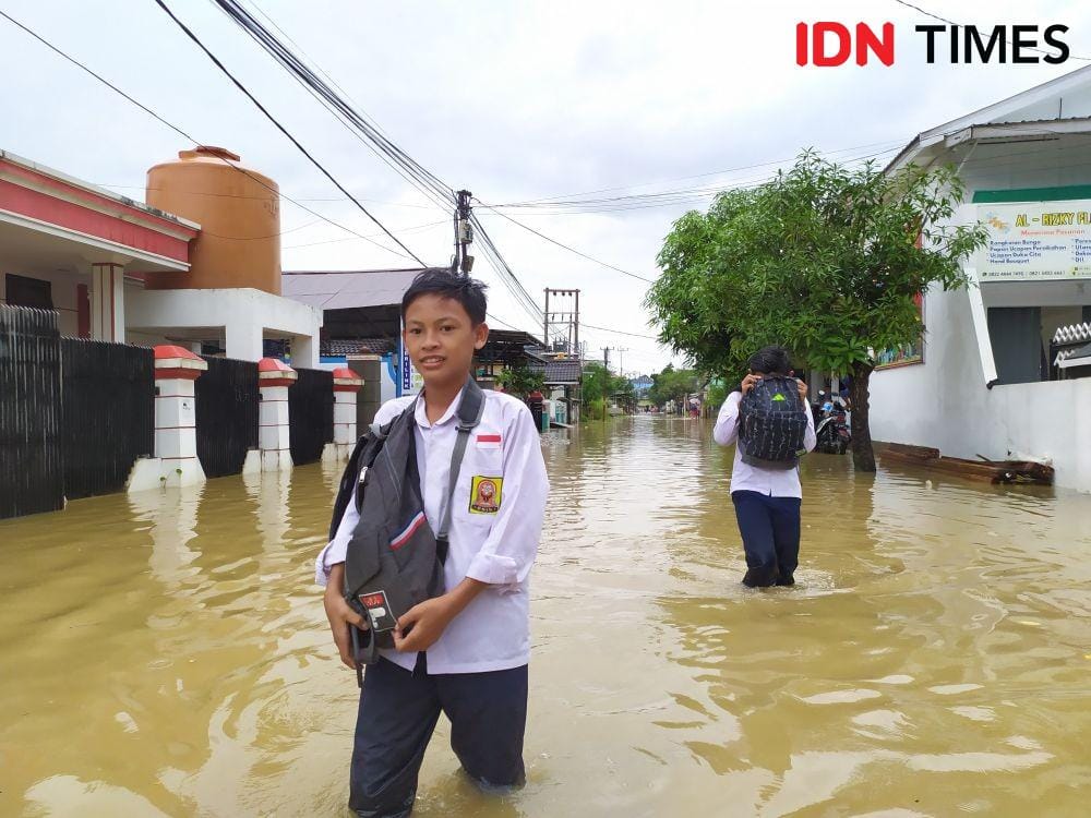 Aldi, pulang sekolah lebih cepat karena air banjir masuk kelas (IDN Times/Yuda Almerio)