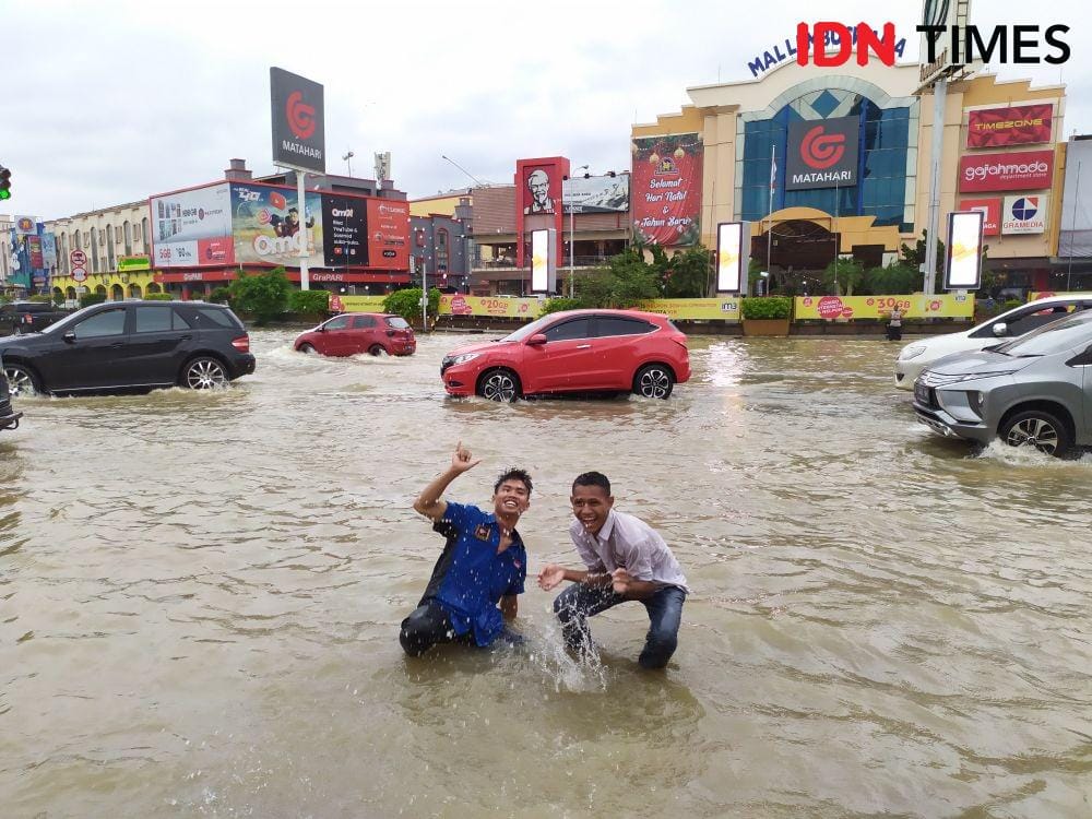 Saat Samarinda dipenuhi genangan Doni (seragam biru) bersama kawannya turun ke jalan membantu warga (IDN Times/Yuda Almerio)
