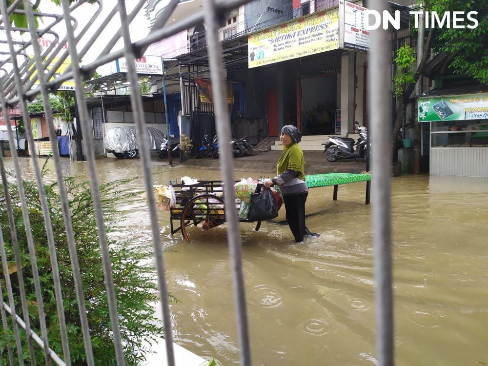 Meskipun banjir melanda Samarinda, pedagang sayur ini tetap semangat berjualan (IDN Times/Yuda Almerio)