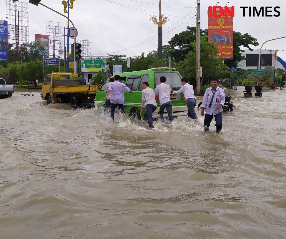 Para pelajar ini turun ke jalan membantu warga sopir yang kesulitan saat banjir di samarinda (IDN Times/Yuda Almerio)