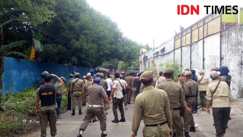 Satpol PP berusaha menghindari lemparan batu saat penertiban Stadion Mattoanging, Rabu (15/1). IDN Times/Asrhawi Muin