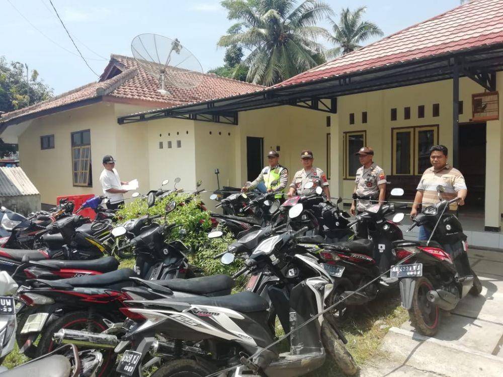 Anggota Polsek Petanahan menunjukkan 36 sepeda motor yang disita saat penggerebekan arena balap liar di Jalan Raya Guyangan - Petanahan Desa Padaurip, Kecamatan Petanahan, Kebumen, Senin (13/1) malam. Humas Polres Kebumen