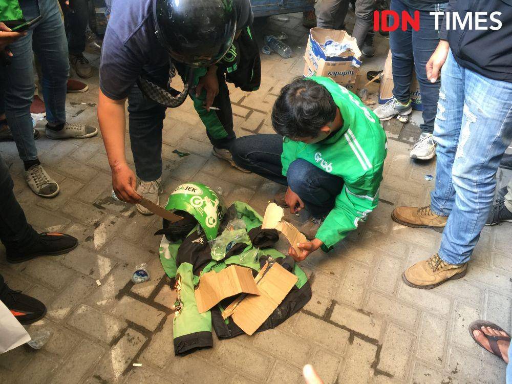 Para driver membakar jaket dan helm sebagai bentuk protes terhadap Gojek (IDN Times/Prayugo Utomo)
