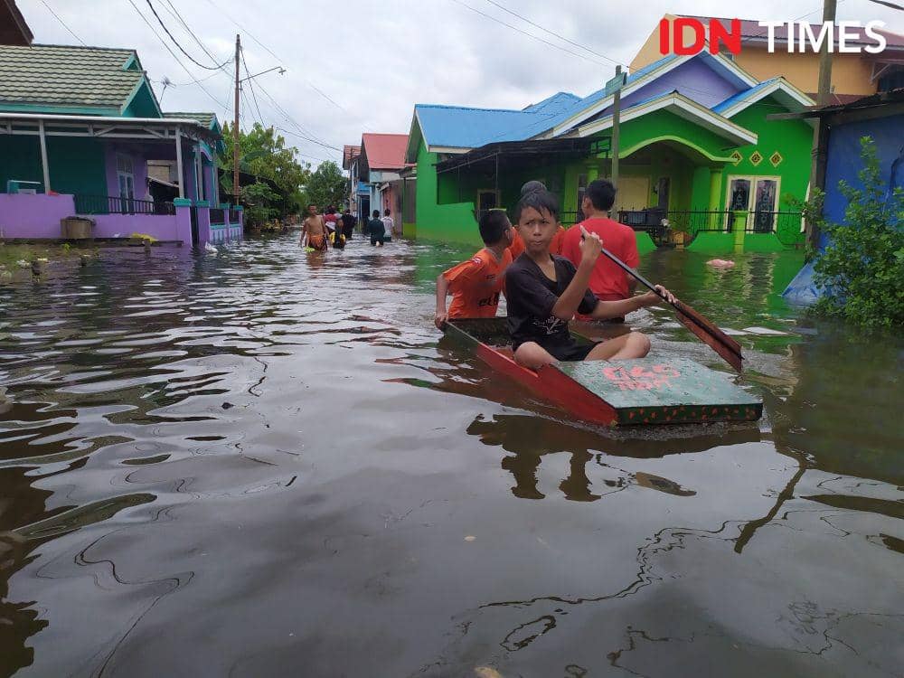 Menghilangkan rasa bosan bocah-bocah di Bengkuring, Samarinda Utara ini memakai sampan mengarungi banjir (IDN Times/Yuda Almerio)