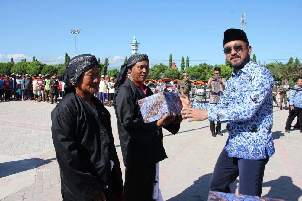 Bupati Ponorogo Ipong Muchlissoni memberikan bantuan dana kepada pengayuh becak secara simbolis, Jumat (16/1). Dok.IDN Times/Istimewa