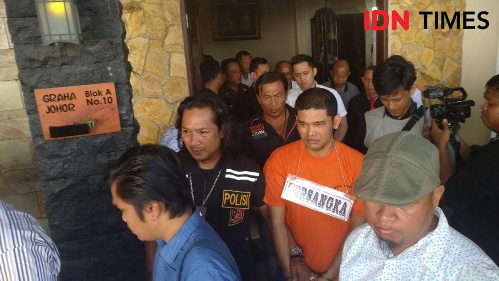 Salah satu tersangka yang membunuh almarhum Jamaluddin diiring petugas keluar dari lokasi rekonstruksi di Graha Johor, Medan Johor, pada Kamis (16/1) (IDN Times/Fadli Syahputra)