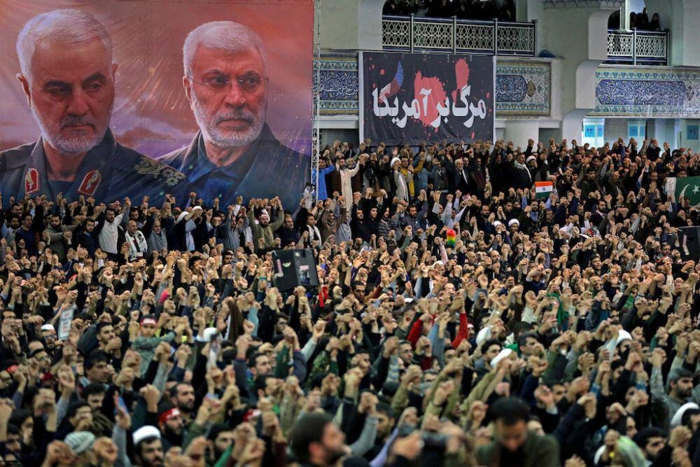 Sebuah poster dengan gambar mendiang komandan militer Iran Qassem Soleimani dan mendiang komandan milisi Irak Abu Mahdi al-Muhandis, saat jemaah menyerukan slogan selama ceramah Salat Jumat oleh Pemimpin Tertinggi Iran Ayatollah Ali Khamenei, di Tehran, Iran, pada 17 Januari 2020. ANTARA FOTO/Official Khamenei website/Handout via REUTERS