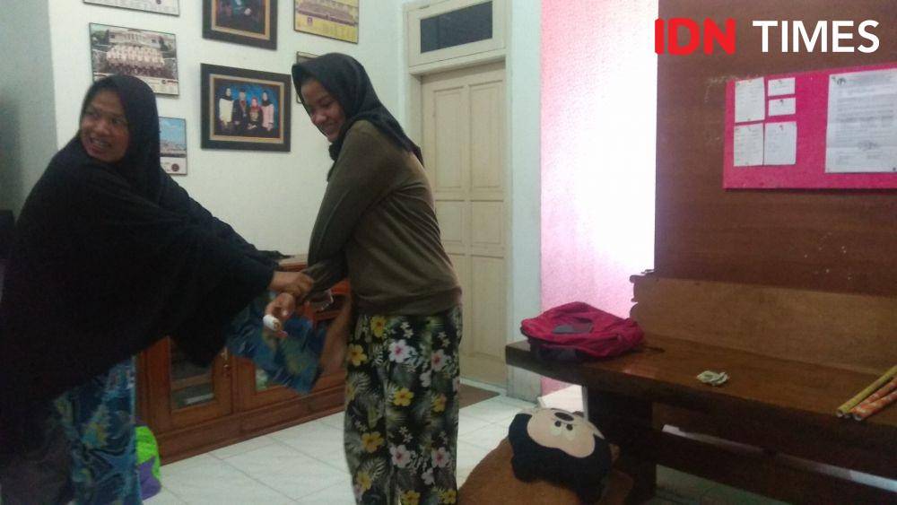 Ibu dan anak, Elis Aryani dan anaknya Yusni Widya Utami tengah memperagakan adegan memiting perampok di rumahnya. (IDN Times/Wildan Ibnu)